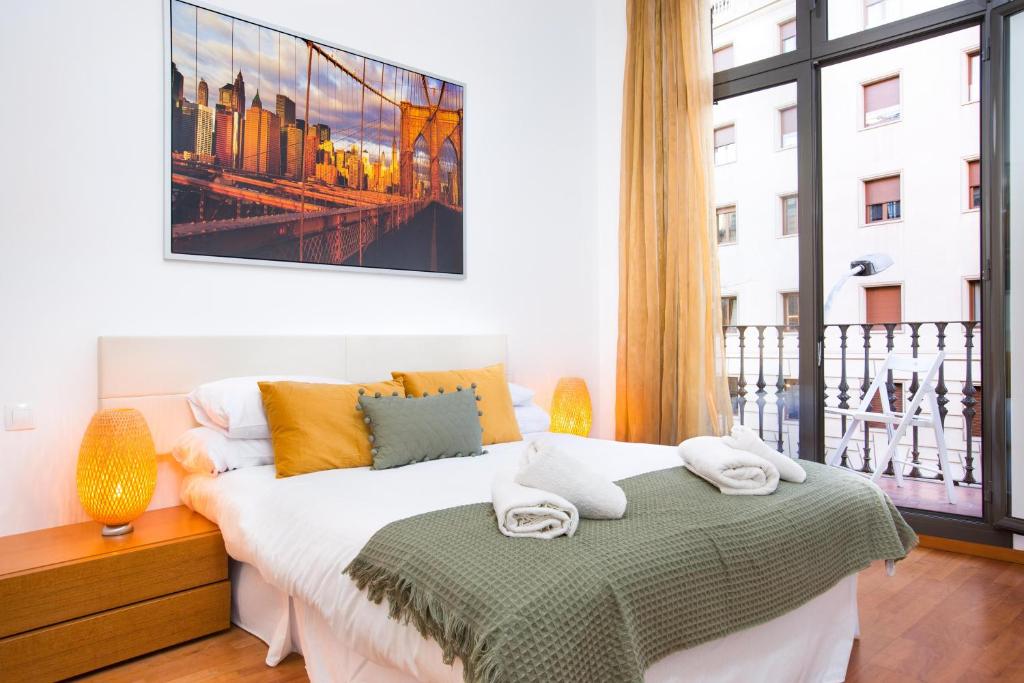 a bedroom with a bed and a large window at Stay U-nique Apartments Balmes in Barcelona