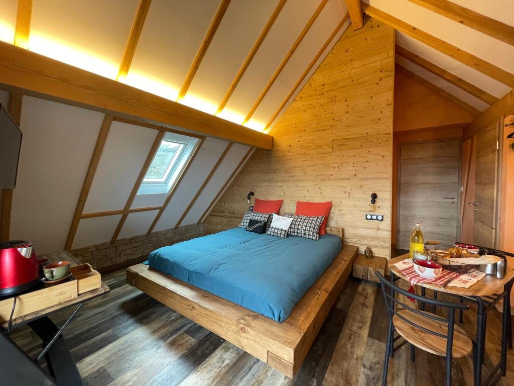 a bedroom with a bed and a table in a room at Le Refuge du Rempart in Dambach-la-Ville