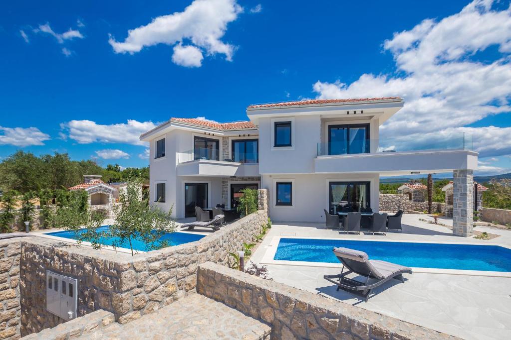 une villa avec une piscine et une maison dans l'établissement Villa ELA - Town Krk, à Krk