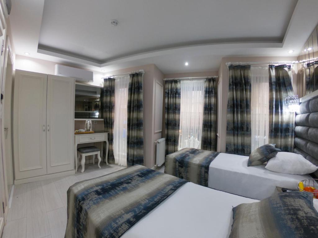 a bedroom with two beds and a desk at Crowned Hotel in Istanbul