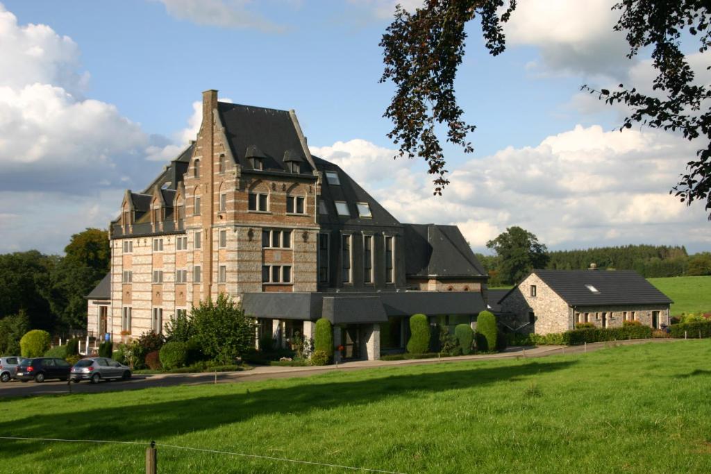 a large stone building with a black roof at Chaityfontaine in Pepinster