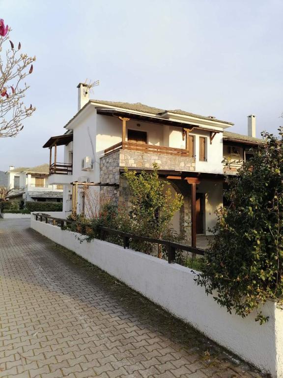 a white house on the side of a street at Harmony seaside apartments in Koropi