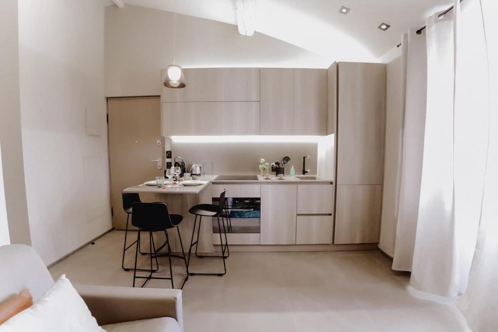 a small kitchen with white cabinets and a table and chairs at Le Beach in Saint-Tropez