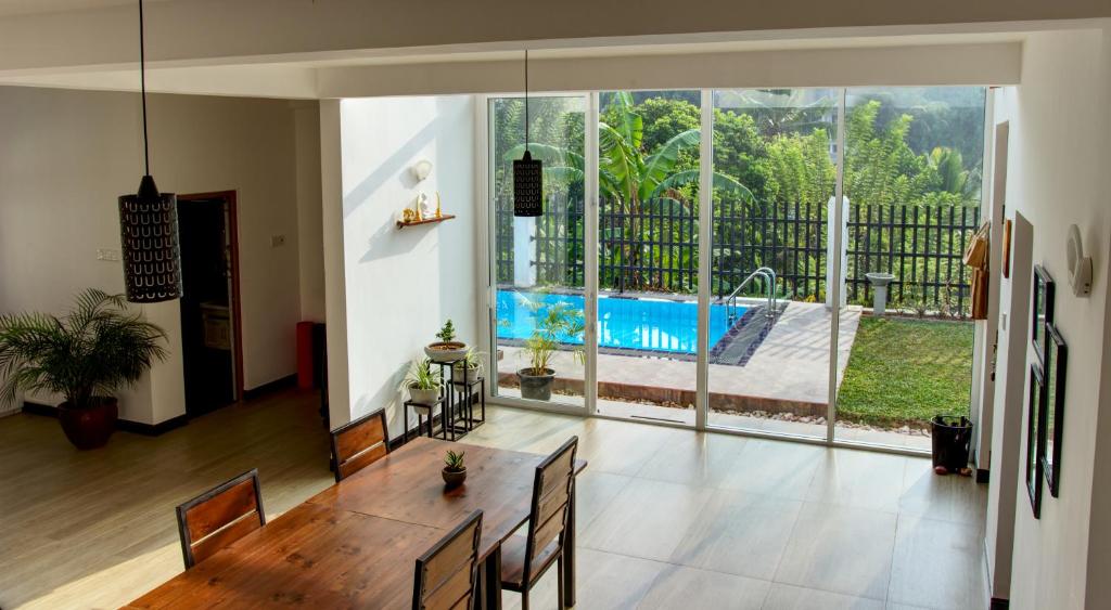 a dining room with a table and a view of a pool at De Paris à Kandy in Kandy