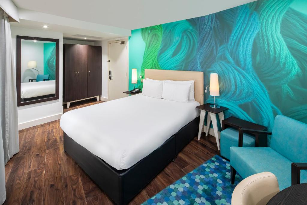 um quarto de hotel com uma cama e um sofá azul em Hotel Indigo Liverpool, an IHG Hotel em Liverpool