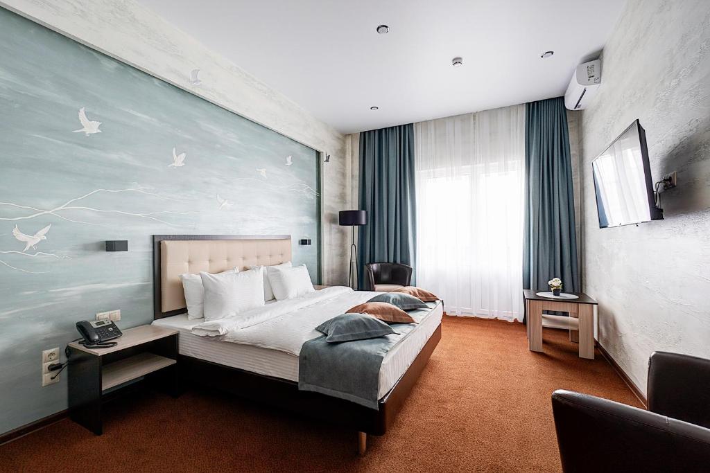 トヴェリにあるPremier Hotelのベッドルーム1室(壁に絵画が描かれた大型ベッド1台付)
