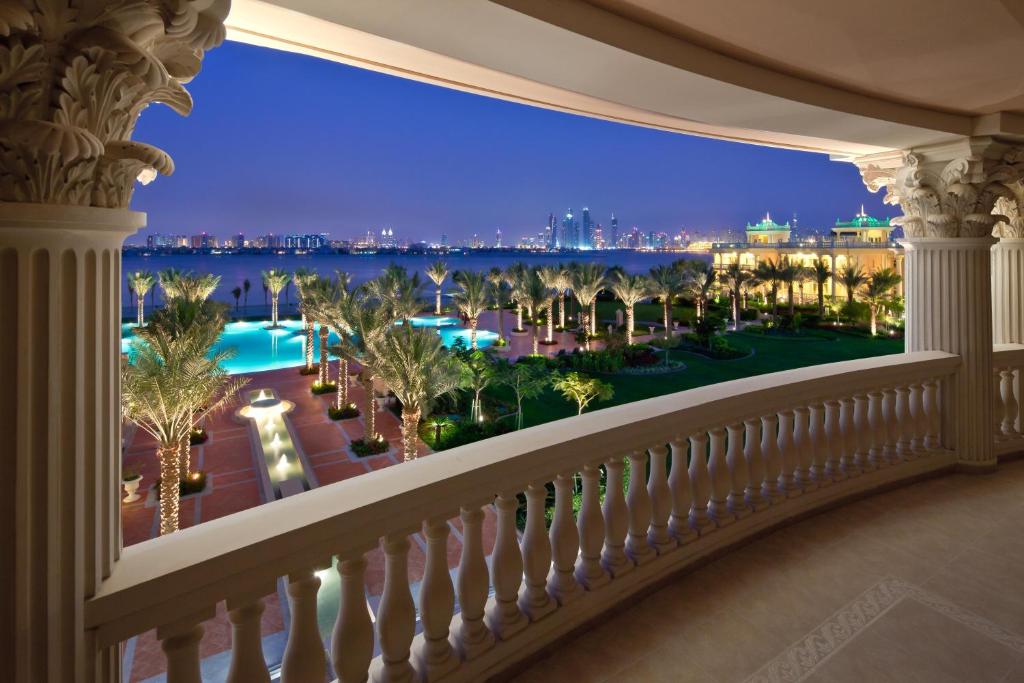 a balcony with a view of the city at night at Kempinski Hotel Palm Jumeirah in Dubai