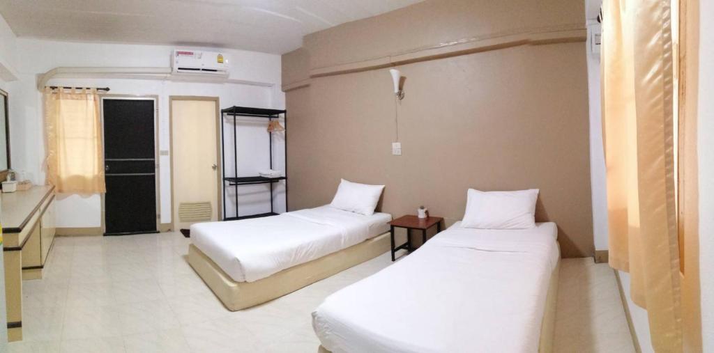 a hotel room with two beds and a window at Phuviewplace Hotel - โรงแรมภูวิวเพลส in Ban Ngun