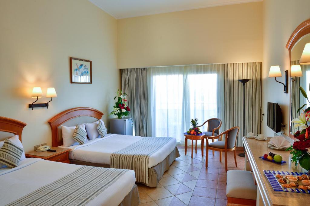A bed or beds in a room at Sharm Grand Plaza Resort - Families and Couples Only