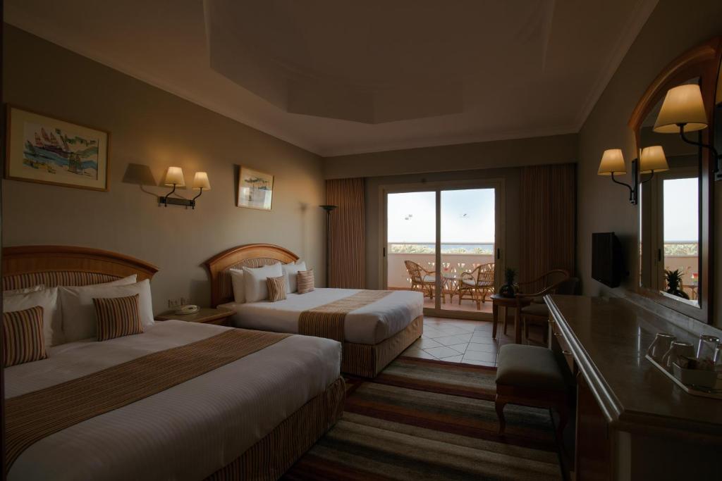 A bed or beds in a room at Sharm Grand Plaza Resort - Families and Couples Only