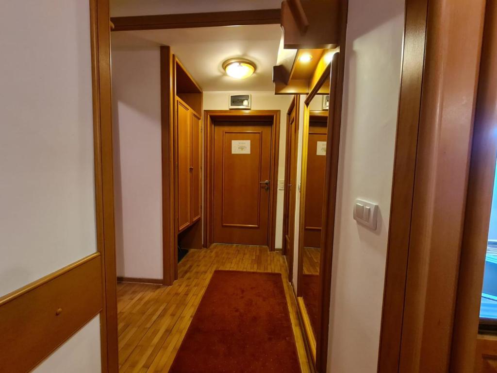 een hal met een deur en een kleed in een kamer bij Apartman 602 in Kopaonik