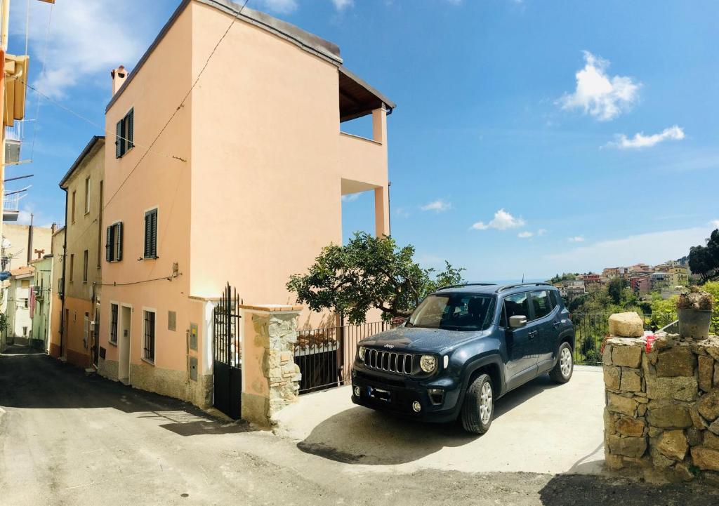 a blue jeep parked in front of a house at Alba Rosa Niususu in Lanusei