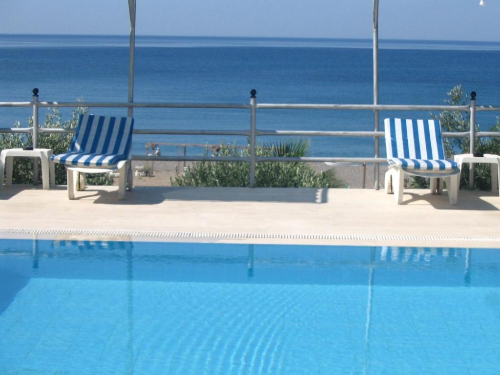 two blue and white chairs sitting next to a swimming pool at Hotel Schönberg in Kızılot