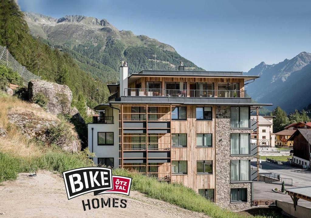 a large building on a hill with a sign in front of it at Valentin Design Apartments in Sölden