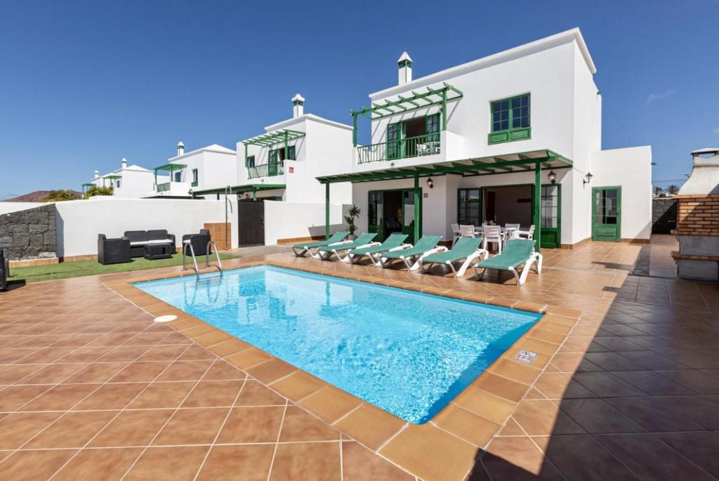 eine Villa mit einem Pool vor einem Haus in der Unterkunft Villa Costa Papagayo 6 in Playa Blanca
