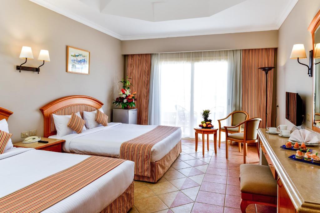 A bed or beds in a room at Sharm Grand Plaza Resort - Families and Couples Only