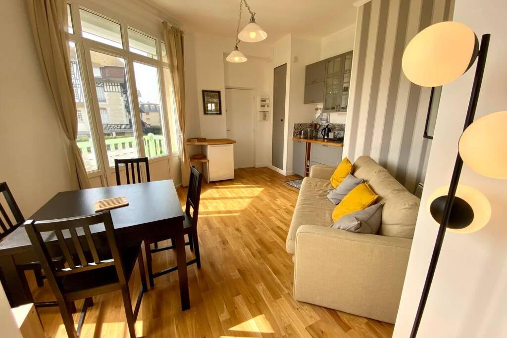 un salon avec une table et un canapé et une salle à manger dans l'établissement EVENTAIL agréable 2 pièces proche mer et ville, à Cabourg