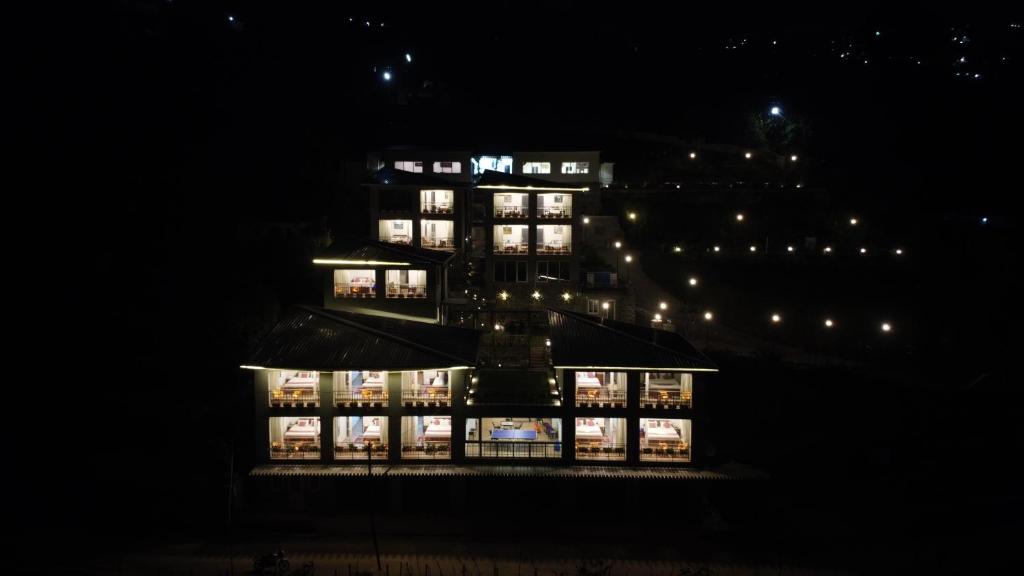 a large building at night with lights at Cherry Blossom Homestay in Kodaikānāl