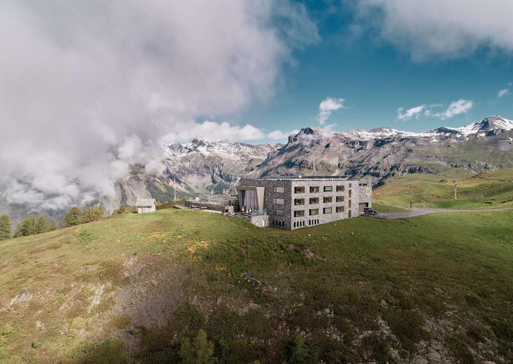 a building on a hill with mountains in the background at chetzeron in Crans-Montana