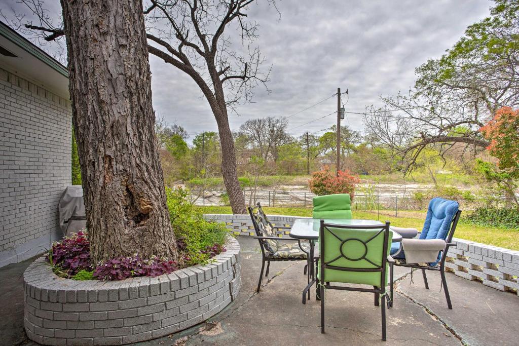 un patio avec des chaises et une table à côté d'un arbre dans l'établissement Creekside Home with Patio and Grill 17 Mi to Dallas!, à Garland