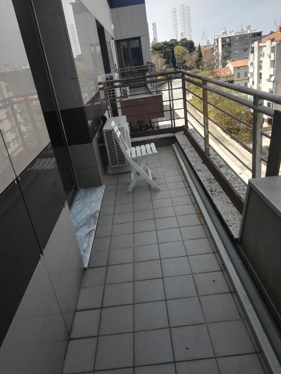 balkon z białym krzesłem na budynku w obiekcie Iva apartman w Puli