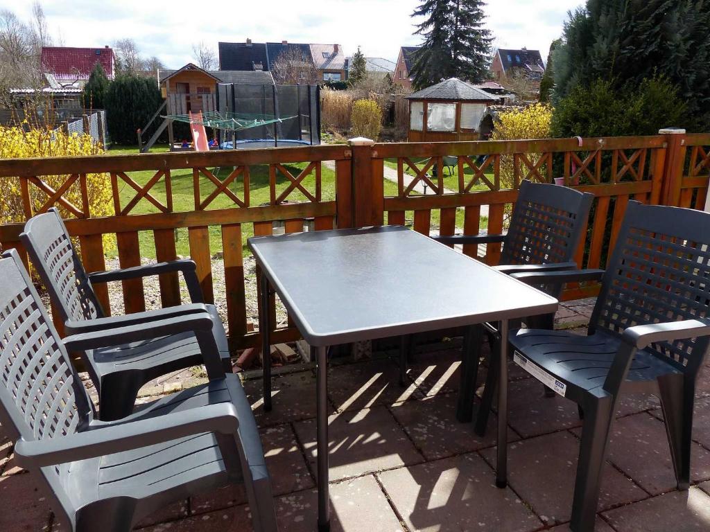 una mesa y sillas en un patio con una valla en Ferienglück in Strandbadnähe von Waren Müritz, en Waren