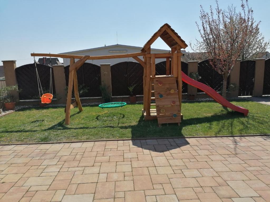 un parque infantil con un tobogán en un patio en Levendulás ház, en Becsehely