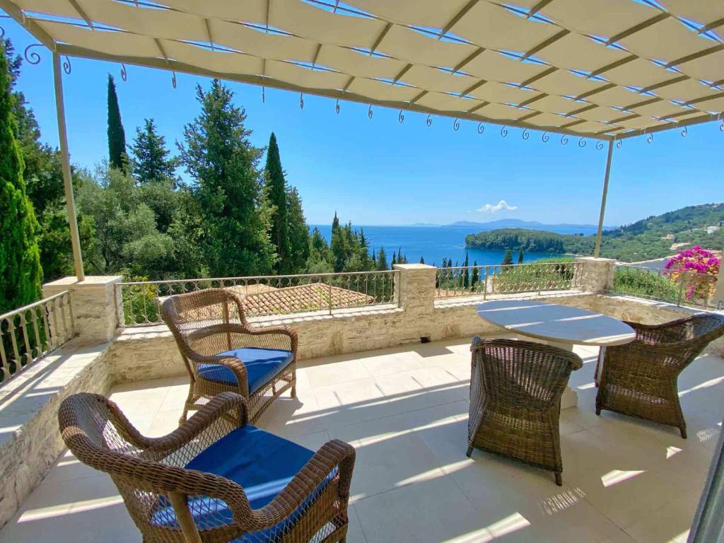 un patio con tavolo, sedie e vista sull'oceano di Paleopetres K-Eight - Premium Suite - Kalami - a Kalámi