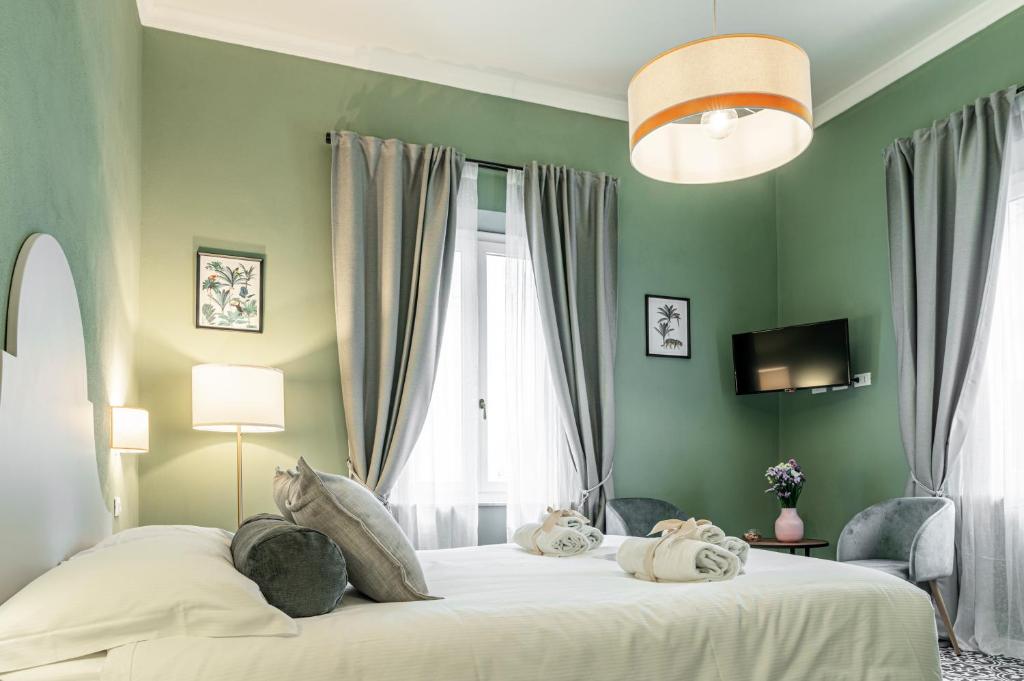 una camera da letto con un grande letto con pareti verdi di La Lu cozy rooms 2 - Self check-in a Pisa