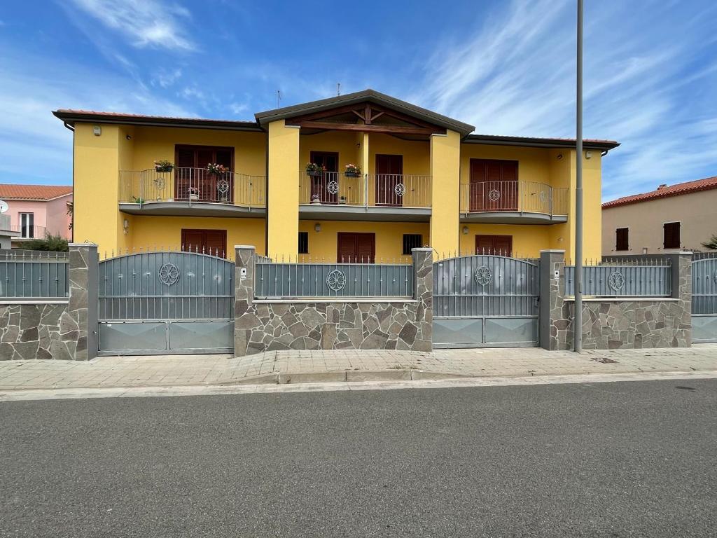 a yellow house with a fence in front of it at Matilde Apartment Pula in Pula