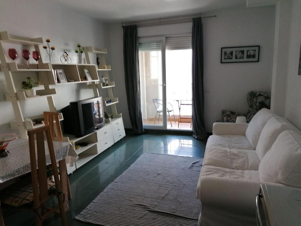 a living room with a white couch and a television at Apartamento ROQUETAS DE MAR MUY CERCA PLAYA in Roquetas de Mar