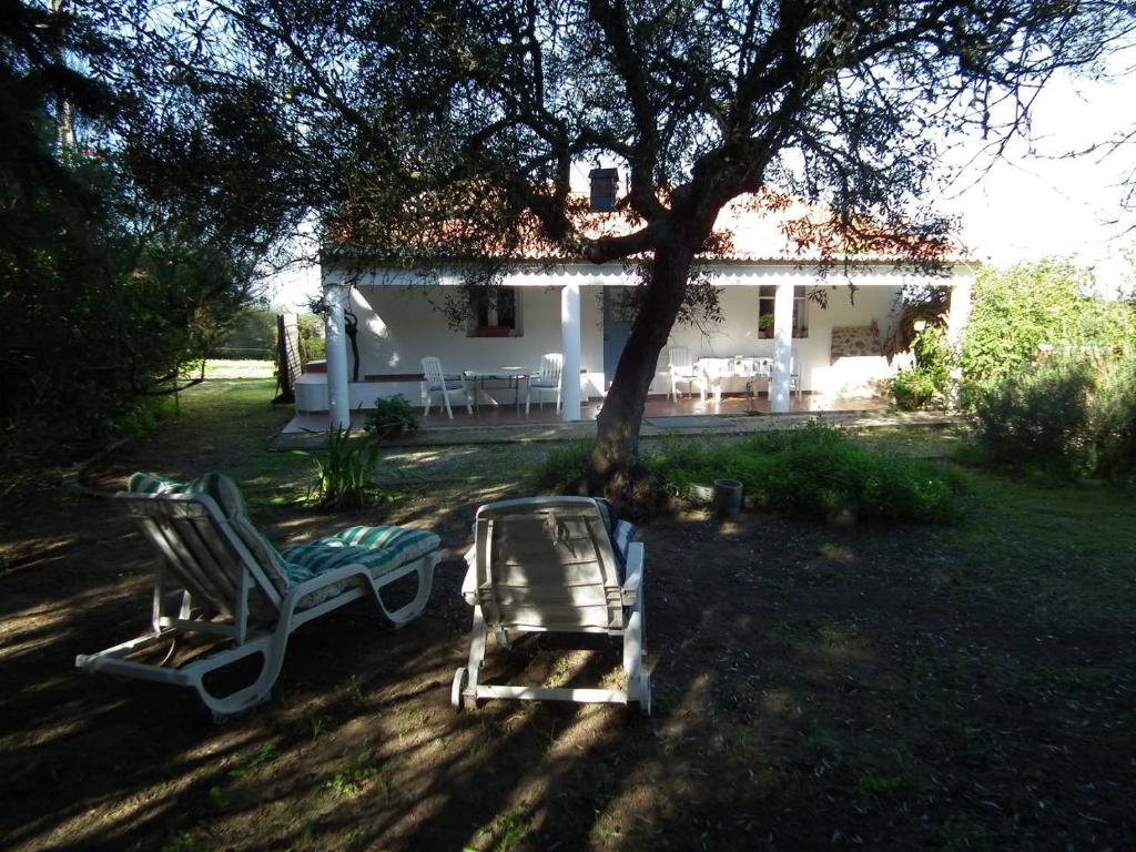 dos sillas de jardín sentadas frente a una casa en Arneiro de Valverde - Nature & Magical Sunset, en Odemira