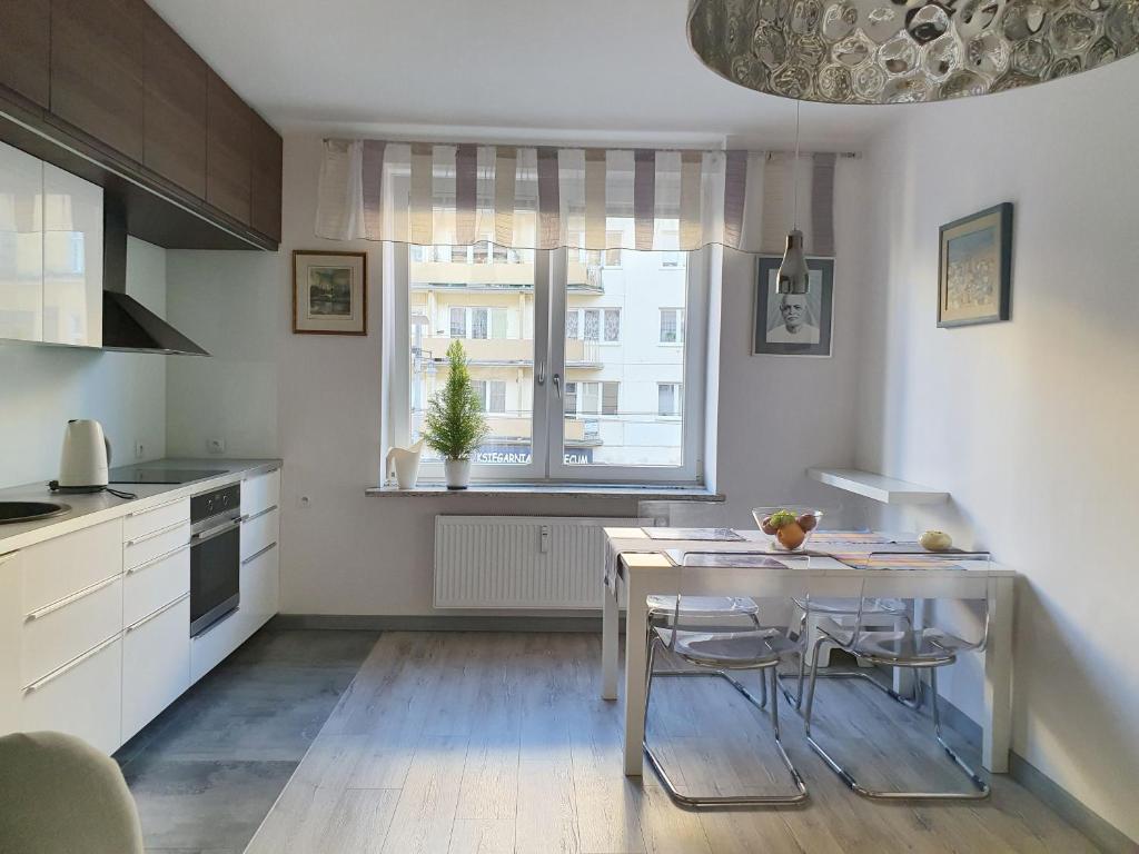 a kitchen with a table and chairs and a window at Apartament Gdynia Świętojańska in Gdynia