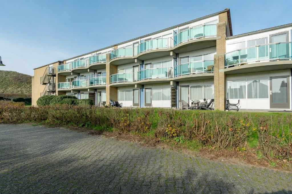 un edificio de apartamentos con un camino delante en Beach appartement 29 - Callantsoog, en Callantsoog