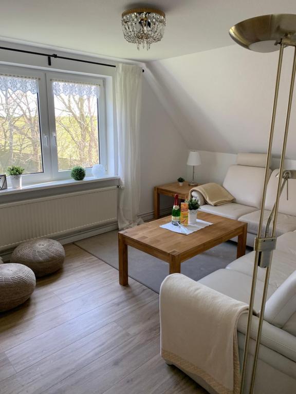 Ferienwohnungen am Aussendeich في نوردستراند: غرفة معيشة مع أريكة وطاولة