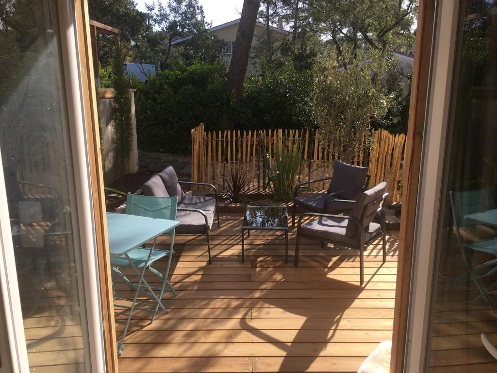 un patio avec des chaises et une table sur une terrasse dans l'établissement Deux pièces ou studio Plage Sud à 200m, à Lacanau-Océan