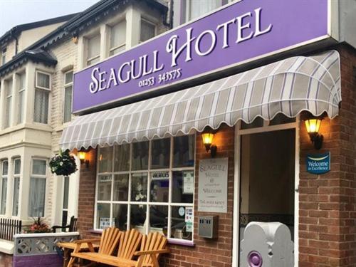 um restaurante com um sinal roxo na frente de um edifício em Seagull Hotel em Blackpool