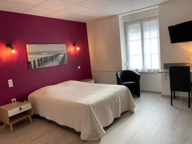a bedroom with a white bed and a purple wall at Pension Gérard in Bourbonne-les-Bains