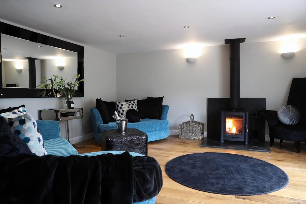 a living room with a blue couch and a fireplace at Pen-Y-Worlod Cottages in Abergavenny