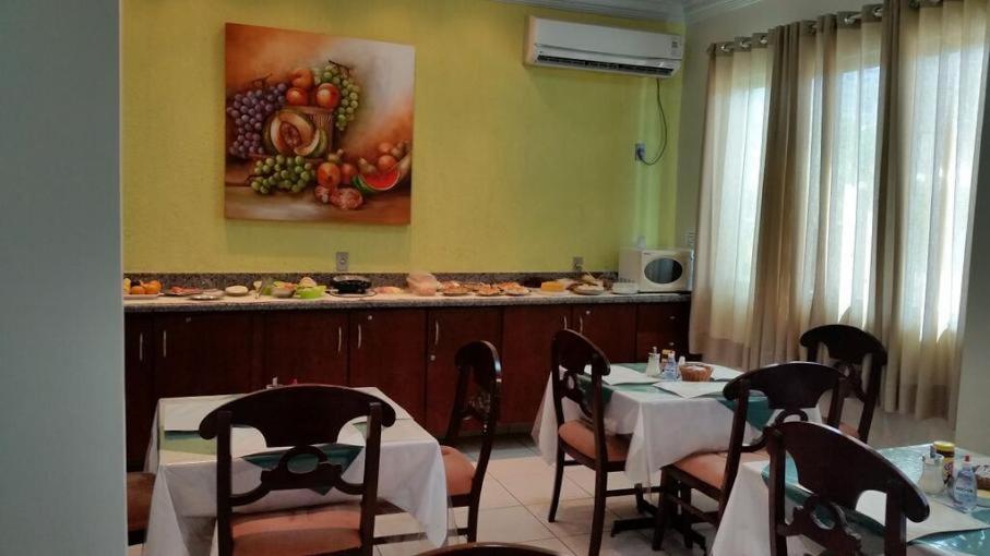 une salle à manger avec des tables et des chaises et une peinture de fruits dans l'établissement Hotel Graciosa Palace, à Palmas