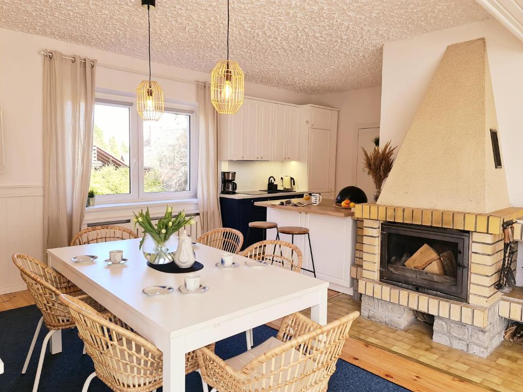 a kitchen and dining room with a table and a fireplace at Baltic House in Kopalino