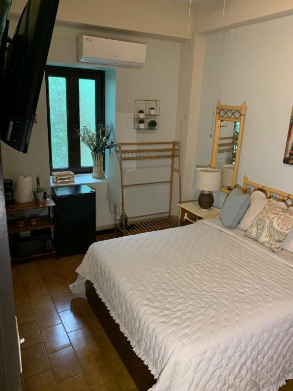 a bedroom with a large white bed and a mirror at The Bambu Room at Casa of Essence located in heart of Old San Juan in San Juan