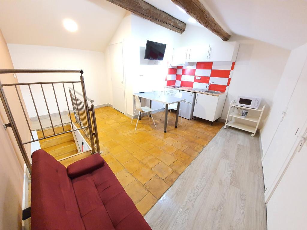 a living room with a red couch and a table at APPARTEMENT AGATHOIS-3 in Agde