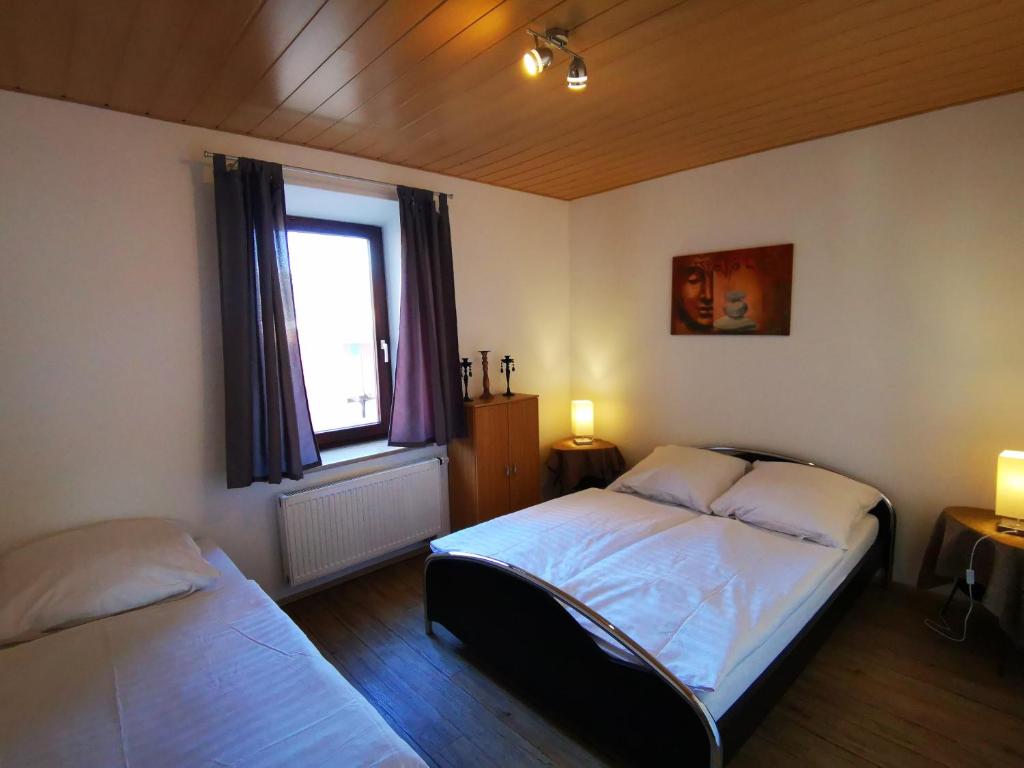 a bedroom with two beds and a window at Stadtdomizil in Augsburg