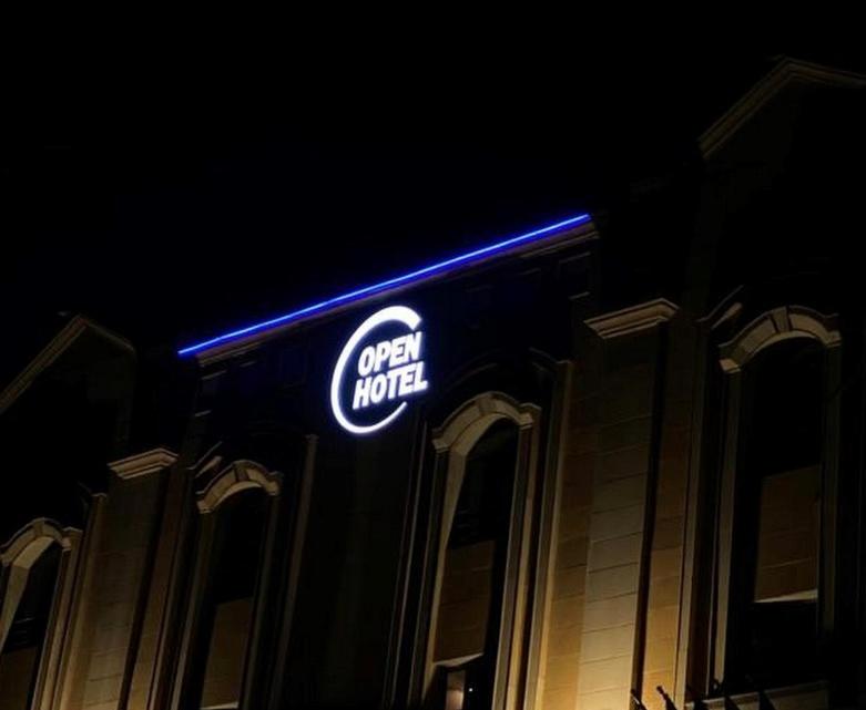 a lit up sign on the side of a building at Open ApartHotel in Dammam