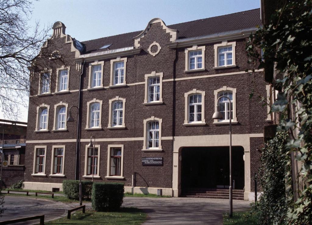 un gran edificio de ladrillo con un gran garaje en Jugendherberge Duisburg Landschaftspark, en Duisburg