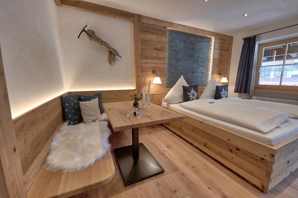 1 dormitorio con 1 cama grande y 1 mesa en Gästehaus Zum Wurm en Reit im Winkl