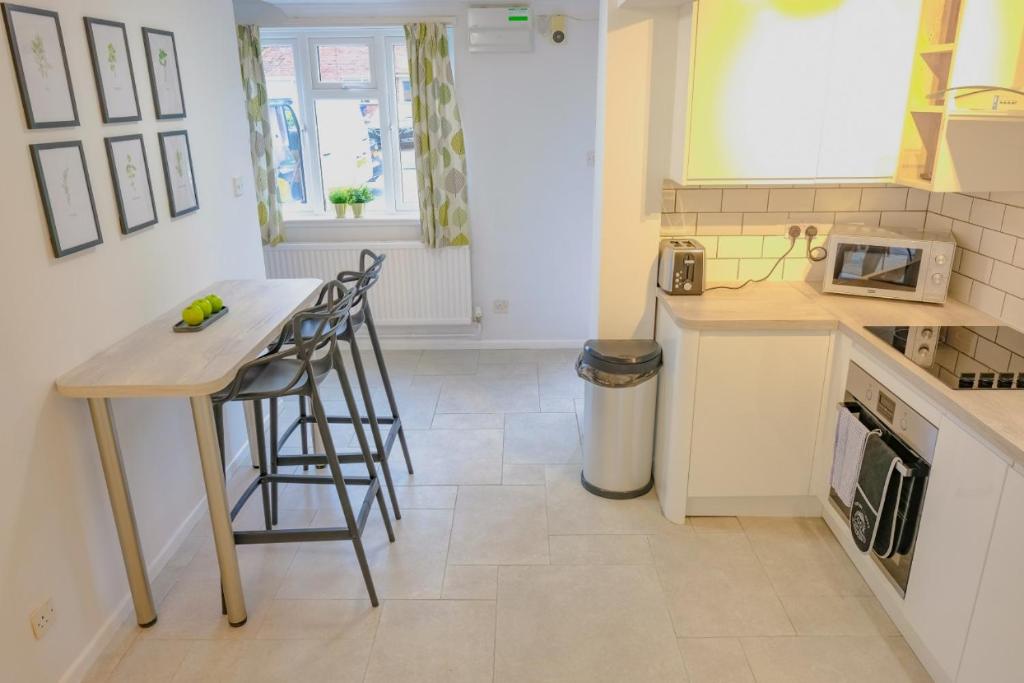 uma cozinha com uma mesa e cadeiras numa cozinha em Artistic & Modern Design Humphreys Lodge - Sleep 6 em Chesterton