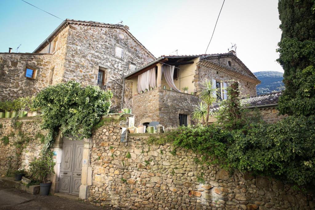 an old stone house with a stone wall at Le Mas Fraissinet in Saint-Jean-de-Valériscle