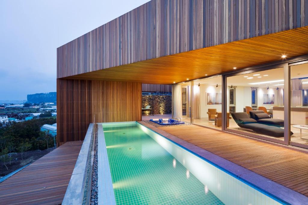a house with a swimming pool and a living room at Bayhill Pool & Villa in Seogwipo